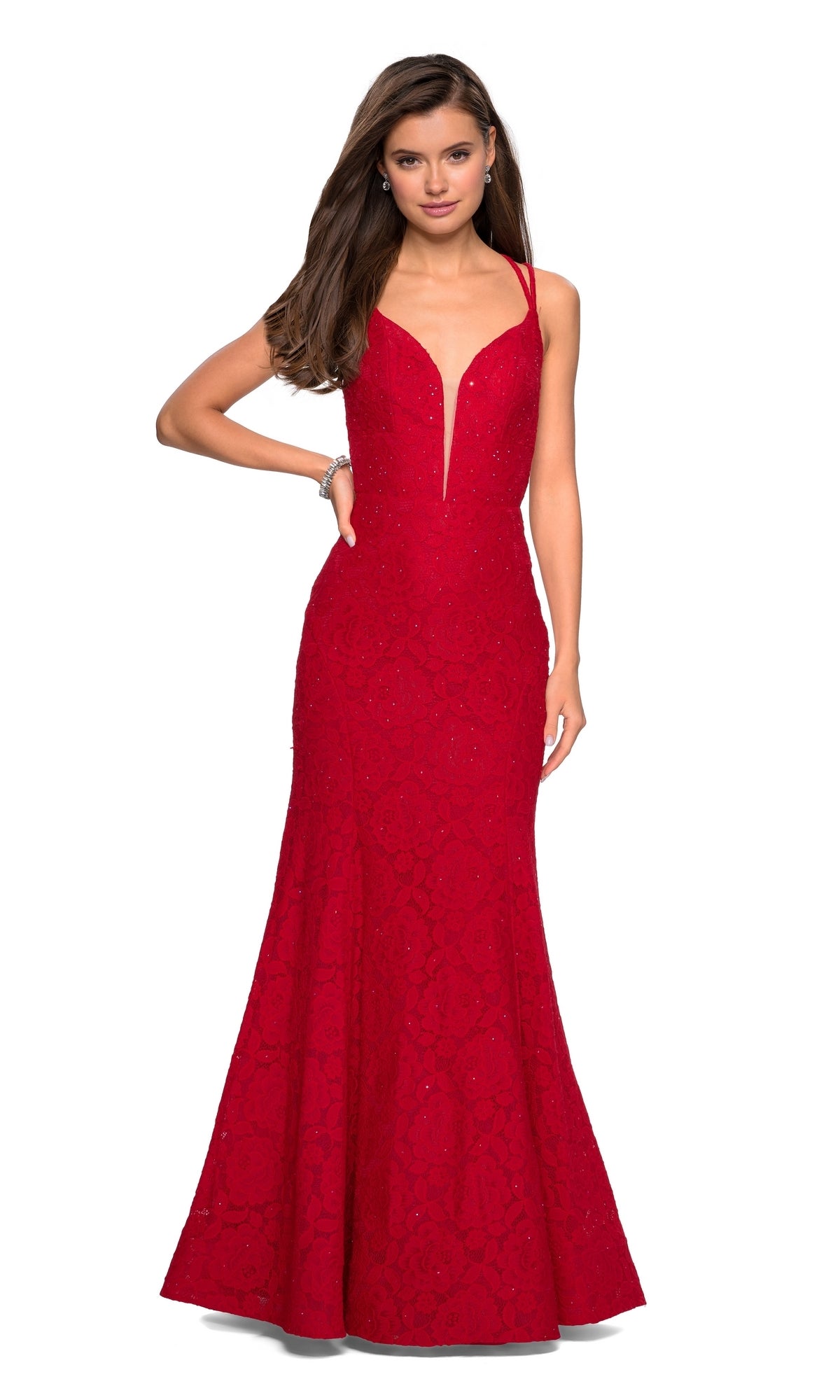 A woman models the La Femme 27560 Backless Lace Mermaid Prom Dress, a sleeveless, fitted red gown with a deep V neckline, standing against a white background.